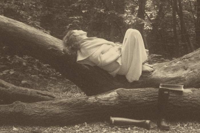 Portrait of Hajnalka Cecilia sitting on a log in a forest
